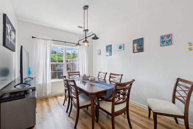 dining space with light wood-style floors, baseboards, and visible vents