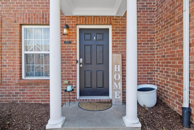 doorway to property featuring brick siding