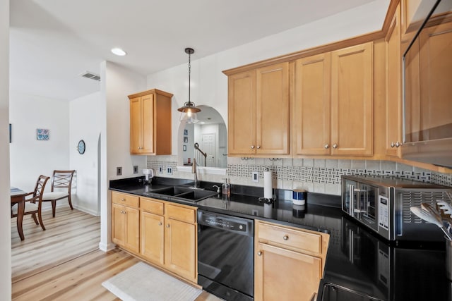 kitchen with visible vents, dark countertops, light wood-style floors, black dishwasher, and a sink