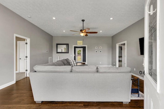 living room featuring recessed lighting, dark wood finished floors, ceiling fan, and baseboards