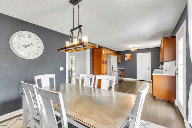 dining room with baseboards and wood finished floors