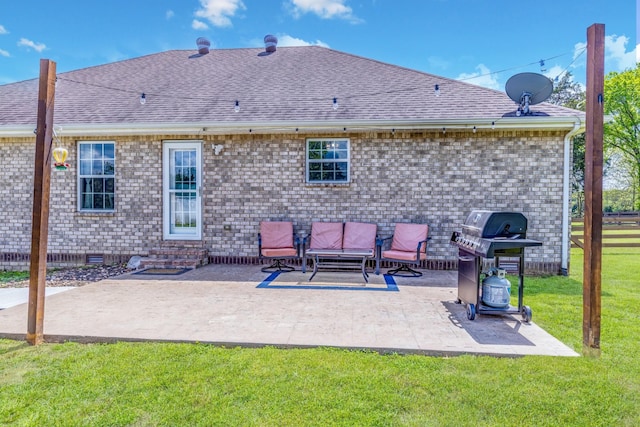 rear view of property with a patio, brick siding, a shingled roof, entry steps, and a yard
