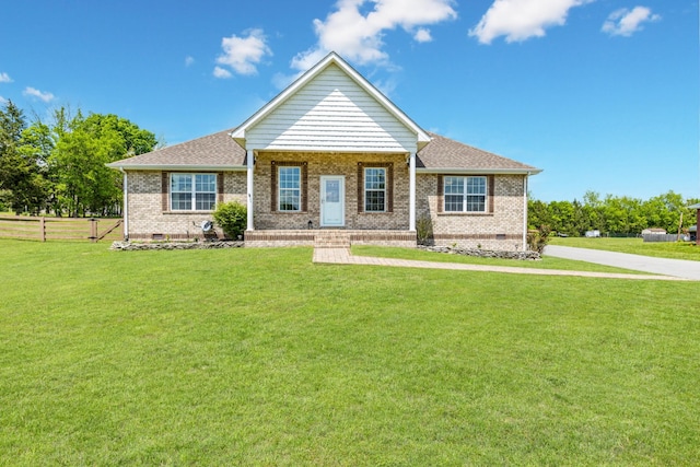 view of front facade with brick siding, fence, a front yard, and crawl space