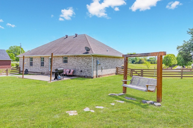 back of house featuring a lawn, a patio area, roof with shingles, and fence