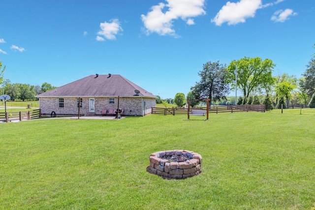 view of yard with fence, a patio, and a fire pit