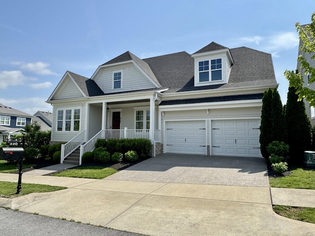 view of front of house featuring a porch, an attached garage, concrete driveway, and a shingled roof
