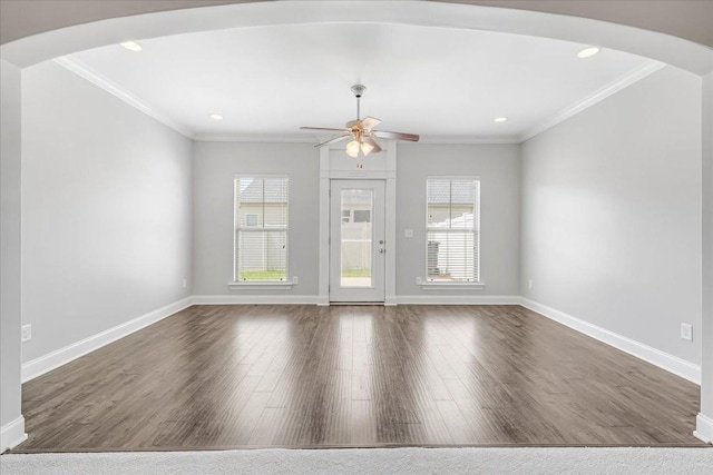 spare room featuring arched walkways, ceiling fan, and a wealth of natural light