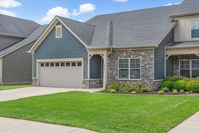 craftsman-style house featuring a garage, a front yard, driveway, and stone siding