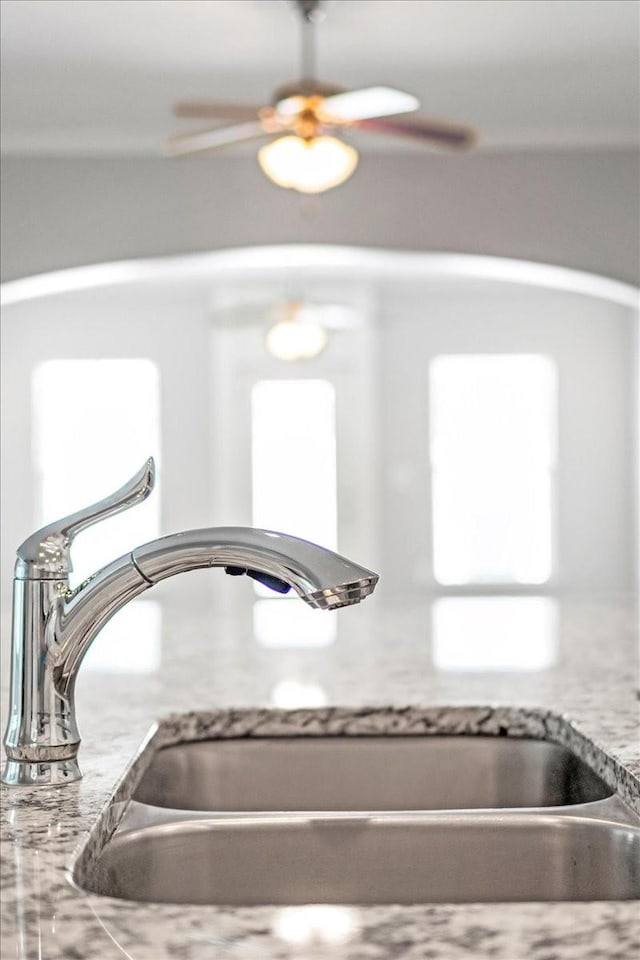 details with light stone countertops and a sink