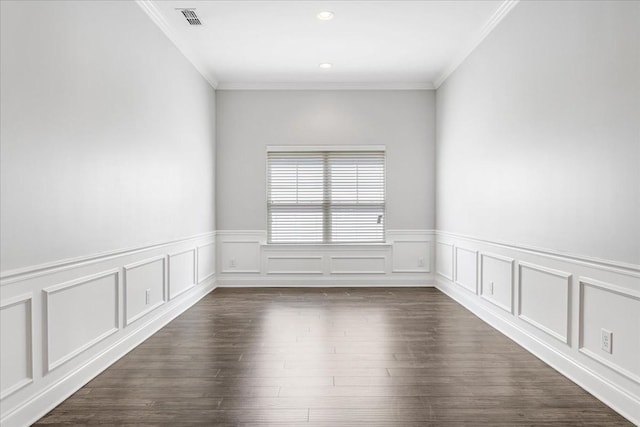 unfurnished room featuring ornamental molding, wainscoting, dark wood-style floors, and visible vents