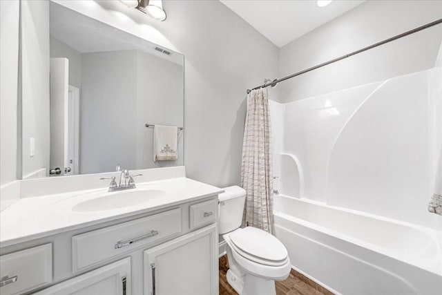 full bath with shower / bath combo, vanity, toilet, wood finished floors, and visible vents