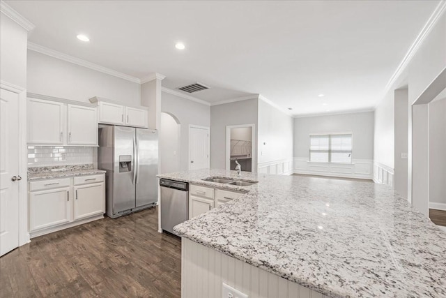 kitchen with visible vents, crown molding, a sink, arched walkways, and stainless steel appliances