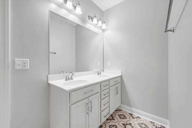 bathroom with double vanity, baseboards, and a sink
