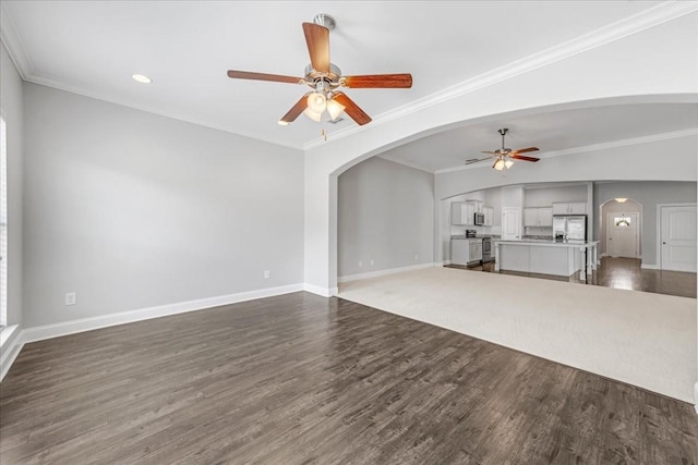 unfurnished living room featuring baseboards, arched walkways, and ceiling fan