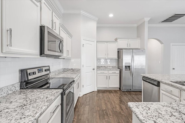 kitchen featuring crown molding, stainless steel appliances, arched walkways, and visible vents