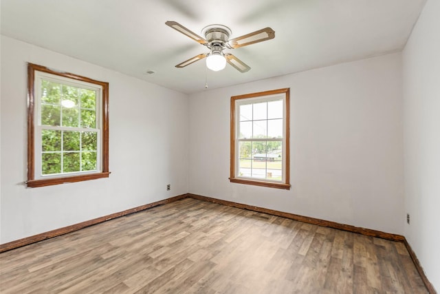 702 1st Ave, Mount Pleasant, TN 38474 - empty room featuring light wood-style floors, baseboards, plenty of natural light, and a ceiling fan