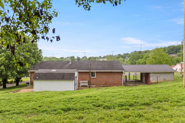 702 1st Ave, Mount Pleasant, TN 38474 - rear view of property featuring a lawn, an outdoor structure, and brick siding