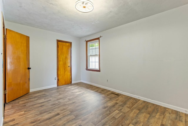 702 1st Ave, Mount Pleasant, TN 38474 - empty room featuring baseboards, visible vents, and wood finished floors