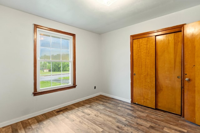 702 1st Ave, Mount Pleasant, TN 38474 - unfurnished bedroom with baseboards, multiple windows, wood finished floors, and visible vents