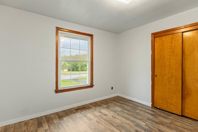 702 1st Ave, Mount Pleasant, TN 38474 - unfurnished bedroom featuring baseboards, a closet, wood finished floors, and visible vents