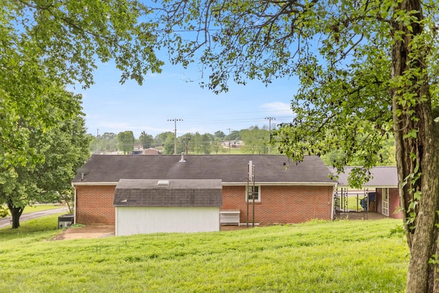 702 1st Ave, Mount Pleasant, TN 38474 - back of property with central air condition unit, a shingled roof, a yard, and brick siding