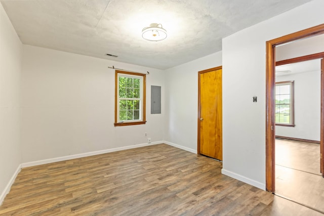 702 1st Ave, Mount Pleasant, TN 38474 - unfurnished room featuring baseboards, visible vents, wood finished floors, and electric panel