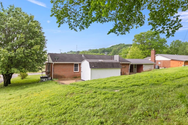 702 1st Ave, Mount Pleasant, TN 38474 - back of house featuring a lawn, a patio area, and brick siding