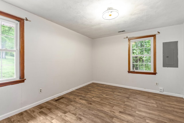 702 1st Ave, Mount Pleasant, TN 38474 - unfurnished room featuring baseboards, electric panel, wood finished floors, and visible vents