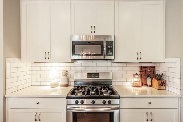 196 Dayflower Dr, Hendersonville, TN 37075 - kitchen with backsplash, stainless steel appliances, light stone counters, and white cabinetry