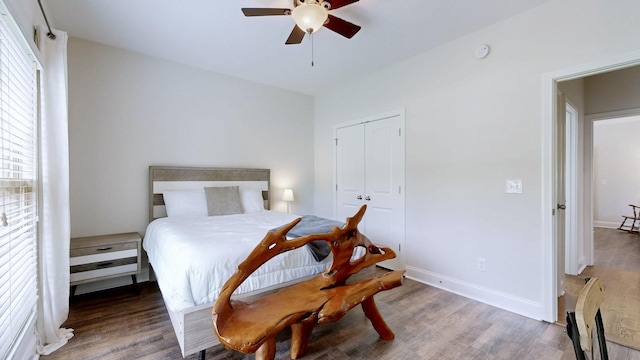 bedroom with baseboards, wood finished floors, and a closet