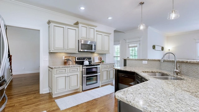 kitchen featuring crown molding, decorative backsplash, light wood-style floors, a sink, and stainless steel appliances