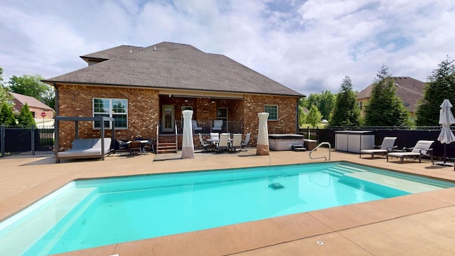 view of pool featuring a hot tub, a patio, fence, and a fenced in pool