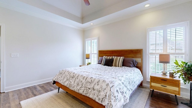 bedroom featuring ornamental molding, wood finished floors, and multiple windows