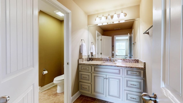 bathroom with vanity, visible vents, toilet, baseboards, and tile patterned floors