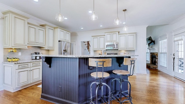 kitchen with appliances with stainless steel finishes, tasteful backsplash, and light wood finished floors