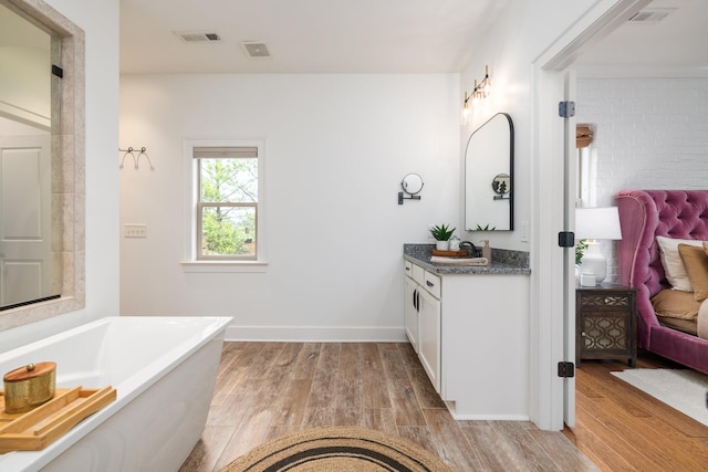 743 Fontwell Ln, Franklin, TN 37064 - bathroom with a freestanding bath, vanity, wood finished floors, and visible vents