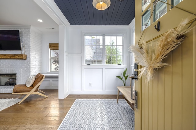 743 Fontwell Ln, Franklin, TN 37064 - entryway with a fireplace, wood-type flooring, a decorative wall, a wainscoted wall, and visible vents