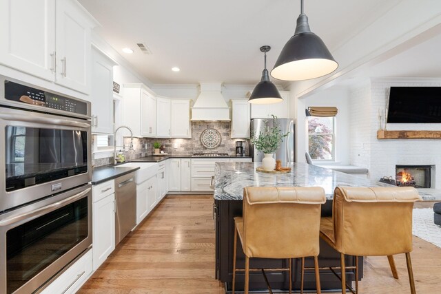 743 Fontwell Ln, Franklin, TN 37064 - kitchen featuring appliances with stainless steel finishes, a sink, open floor plan, custom range hood, and a kitchen island