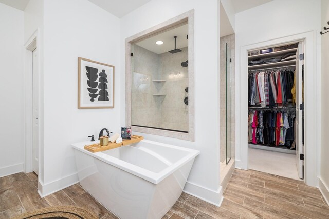 743 Fontwell Ln, Franklin, TN 37064 - bathroom with a freestanding tub, baseboards, wood finish floors, a spacious closet, and a shower stall