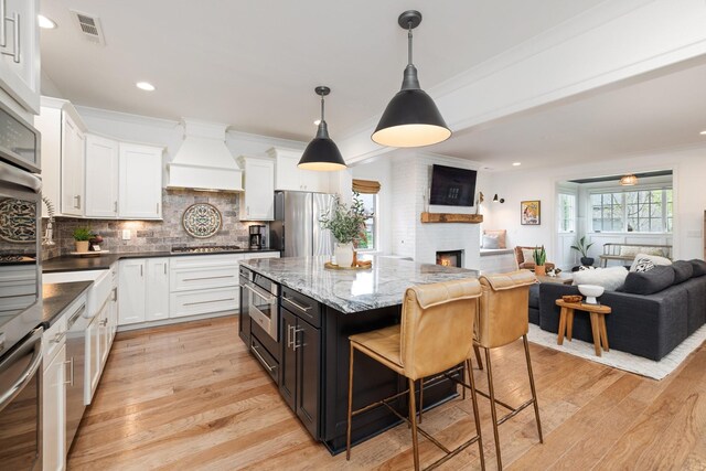 743 Fontwell Ln, Franklin, TN 37064 - kitchen with white cabinetry, open floor plan, visible vents, and custom exhaust hood