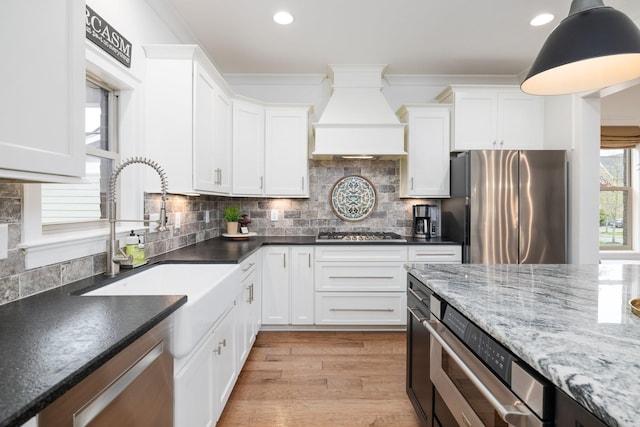 743 Fontwell Ln, Franklin, TN 37064 - kitchen featuring premium range hood, light wood-type flooring, white cabinetry, a sink, and stainless steel appliances