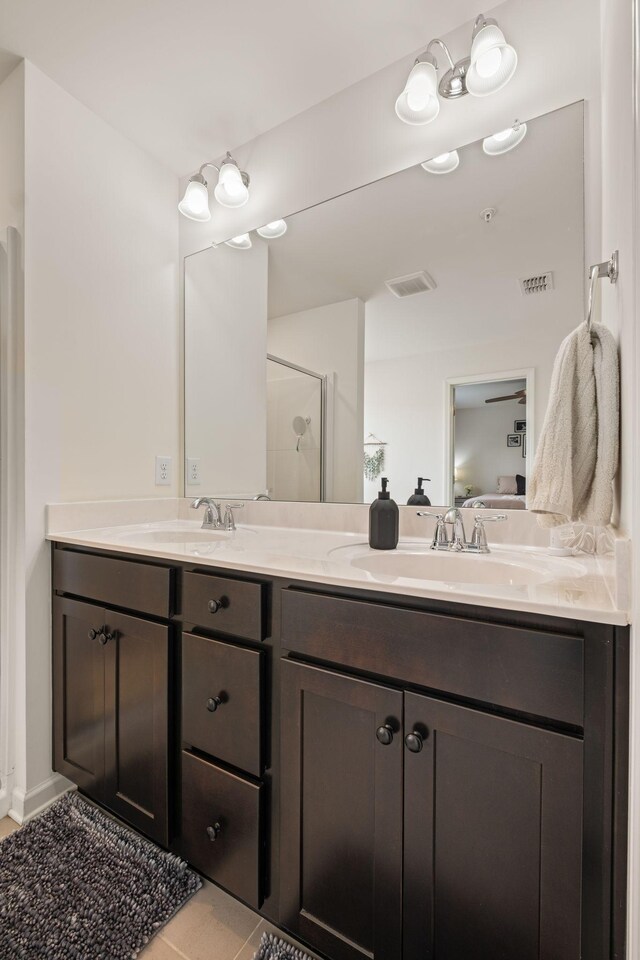 bathroom with connected bathroom, double vanity, and a sink