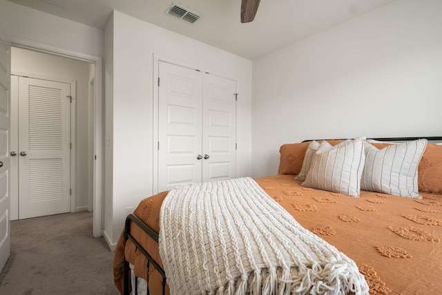 carpeted bedroom with ceiling fan, a closet, and visible vents