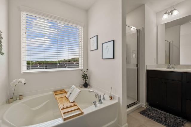 bathroom with a shower stall, a bath, and vanity