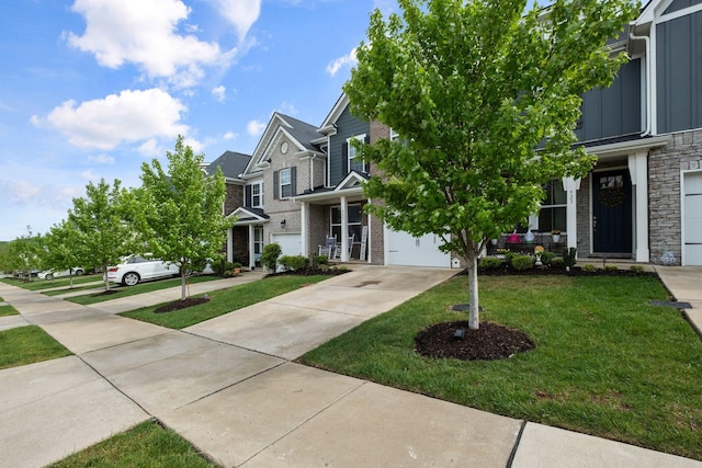 view of front of property featuring board and batten siding, a front yard, driveway, and stone siding