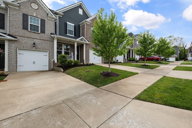 view of front facade with a residential view, concrete driveway, a front yard, and brick siding