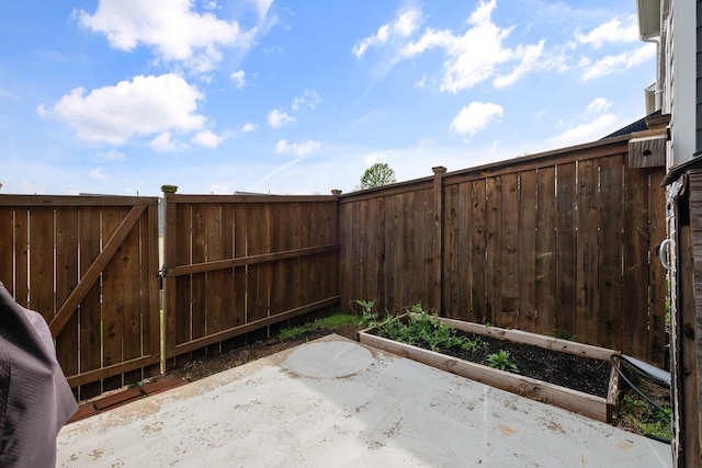 view of patio featuring fence and a vegetable garden