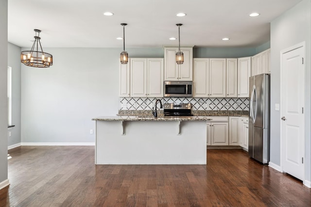 kitchen featuring dark wood finished floors, recessed lighting, stone counters, appliances with stainless steel finishes, and backsplash