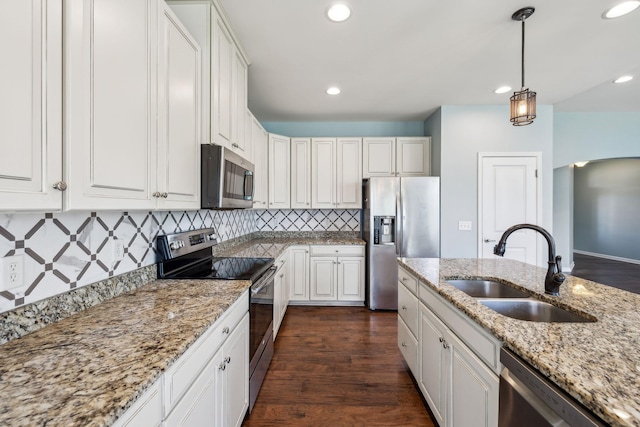 kitchen with decorative backsplash, recessed lighting, dark wood-type flooring, a sink, and stainless steel appliances
