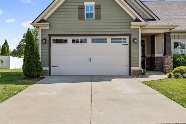 craftsman-style home with board and batten siding, fence, a front yard, and a garage